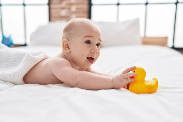 Liebenswertes Kaukasisches Baby Liegt Auf Dem Bett Und Hält Entenspielzeug — Stockfoto