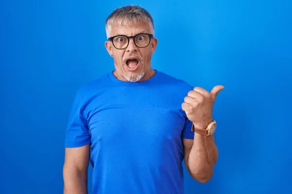 Hispanic Man Grey Hair Standing Blue Background Surprised Pointing Hand — Stock Photo, Image