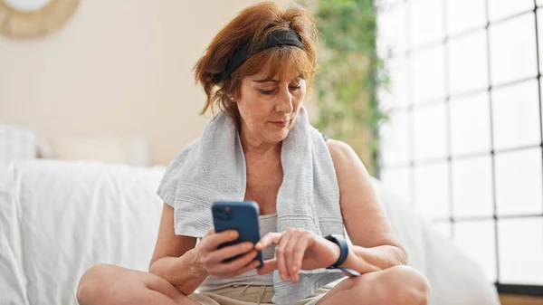 Mulher Meia Idade Sentado Tapete Ioga Usando Smartphone Assistir Quarto — Fotografia de Stock