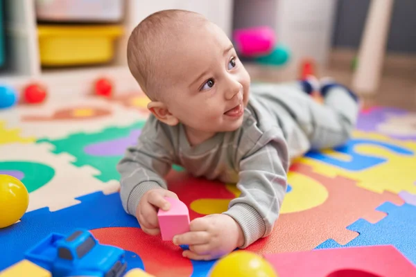 愛らしい白人の赤ちゃん笑顔自信を持って床に横たわっ幼稚園 — ストック写真