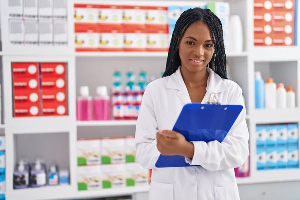 African American Woman Pharmacist Smiling Confident Writing Clipboard Pharmacy — Stockfoto