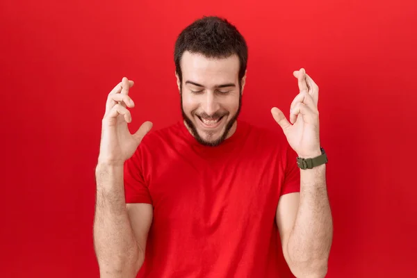 Fiatal Spanyol Férfi Alkalmi Piros Pólót Visel Gesztikuláló Ujját Keresztbe — Stock Fotó