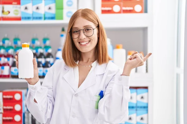 약방에서 일하는 여자가 선크림을 손가락으로 가리키며 행복하게 있습니다 — 스톡 사진