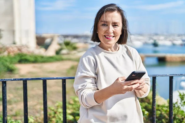 Μέση Ηλικία Γυναίκα Χαμογελώντας Αυτοπεποίθηση Χρησιμοποιώντας Smartphone Στην Παραλία — Φωτογραφία Αρχείου