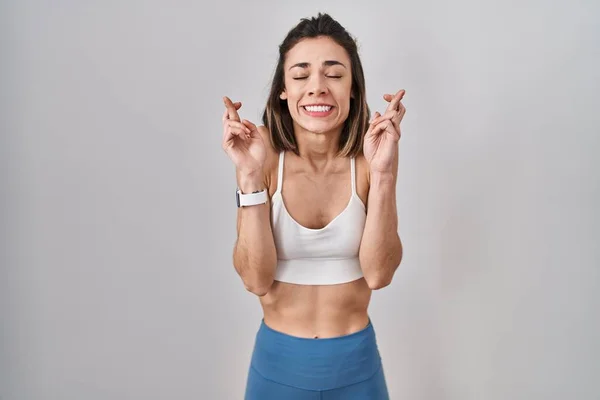 Hispanic Kvinna Bär Sportkläder Över Isolerad Bakgrund Gestikulerande Finger Korsade — Stockfoto