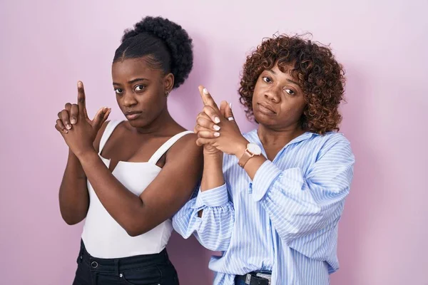 Две Африканки Стоящие Розовом Фоне Держащие Руках Символическое Оружие Стреляющие — стоковое фото