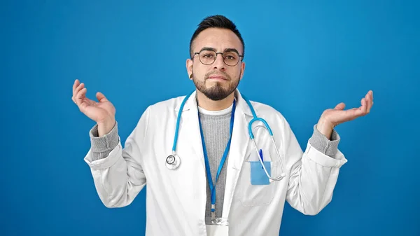 Hispanischer Arzt Steht Ratlos Vor Isoliertem Blauen Hintergrund — Stockfoto