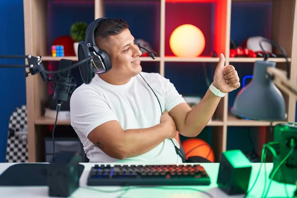 Молодой Латиноамериканец Играющий Видеоигры Выглядит Гордым Улыбаясь Делая Большой Палец — стоковое фото