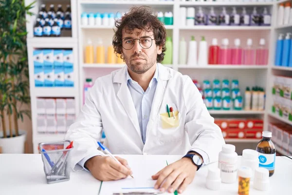 Jovem Hispânico Trabalhando Farmácia Farmácia Cético Nervoso Franzindo Testa Chateado — Fotografia de Stock