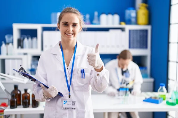 ブロンド女性仕事で科学者研究室笑顔と正 親指アップ行う優れたと承認サイン — ストック写真
