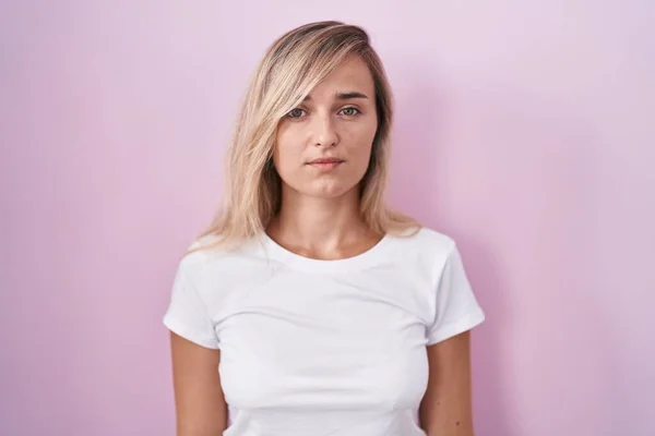 Young Blonde Woman Standing Pink Background Relaxed Serious Expression Face — Stockfoto