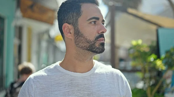 stock image Young hispanic man looking to the side with serious expression at street