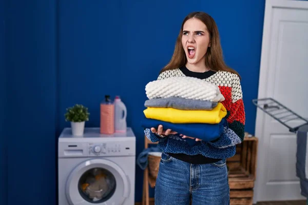 Young Hispanic Girl Holding Clean Laundry Angry Mad Screaming Frustrated — Stock Photo, Image