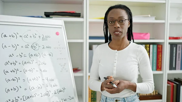 アフリカ系アメリカ人女性教員が大学教室で数学の授業を教えています — ストック写真