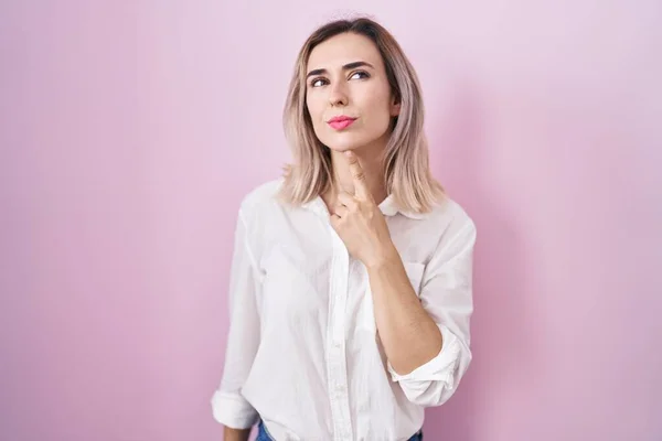 Young Beautiful Woman Standing Pink Background Thinking Concentrated Doubt Finger — Stockfoto