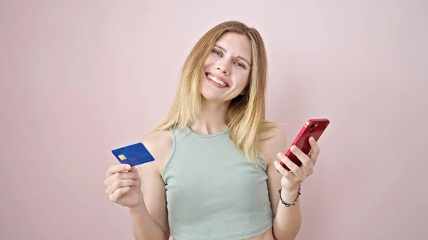 Akıllı Telefon Kredi Kartı Tutan Genç Sarışın Kadın Pembe Arka — Stok fotoğraf