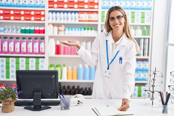 Young Blonde Woman Pharmacist Writing Document Pharmacy — Stok fotoğraf