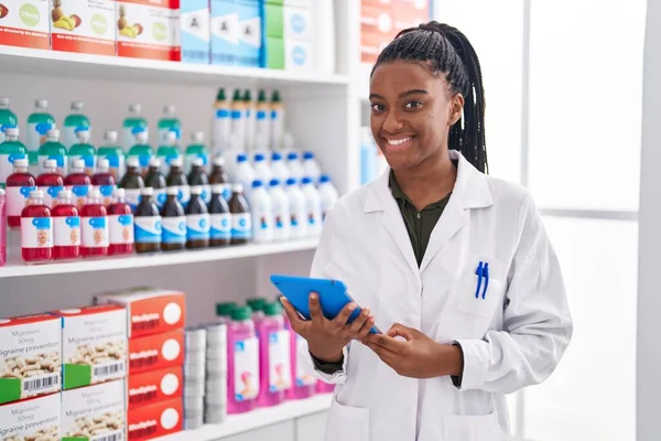 stock image African american woman pharmacist using touchpad working at pharmacy