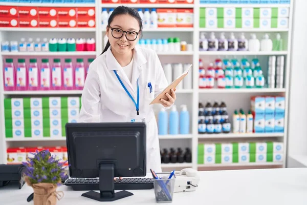 Молодая Китаянка Фармацевт Читает Блокнот Помощью Компьютера Аптеке — стоковое фото