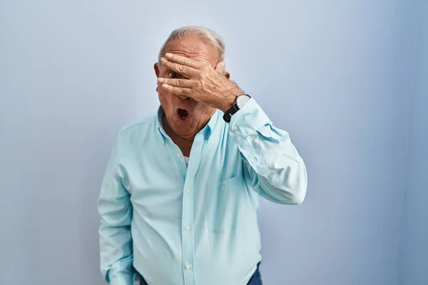 Uomo Anziano Con Capelli Grigi Piedi Sopra Sfondo Blu Sbirciando — Foto Stock