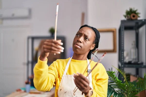 非洲裔美国妇女艺术家在艺术工作室拿着画笔 — 图库照片