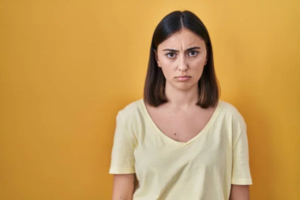 Hispánská Dívka Neformální Tričko Přes Žluté Pozadí Skeptické Nervózní Zamračená — Stock fotografie
