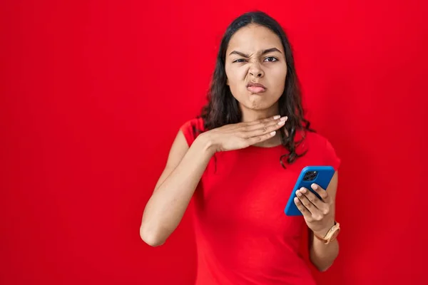 Mladý Brazilský Žena Pomocí Smartphone Přes Červené Pozadí Podříznutí Hrdla — Stock fotografie