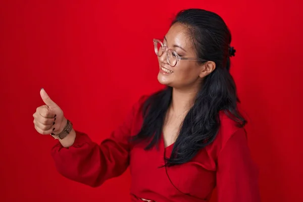Asyalı Genç Bir Kadın Kırmızı Arka Planda Duruyor Gururlu Görünüyor — Stok fotoğraf