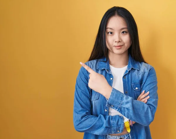 Jonge Aziatische Vrouw Staande Gele Achtergrond Wijzend Met Hand Vinger — Stockfoto