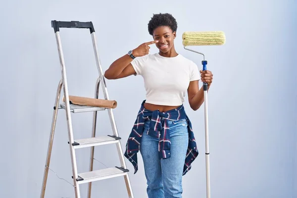 Mulher Afro Americana Segurando Pintor Rolos Apontando Com Dedo Mão — Fotografia de Stock