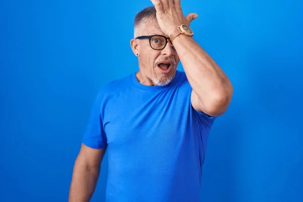 Homem Hispânico Com Cabelos Grisalhos Sobre Fundo Azul Surpreso Com — Fotografia de Stock