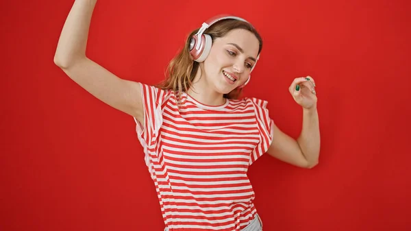 Jeune Femme Blonde Écoutant Musique Dansant Sur Fond Rouge Isolé — Photo