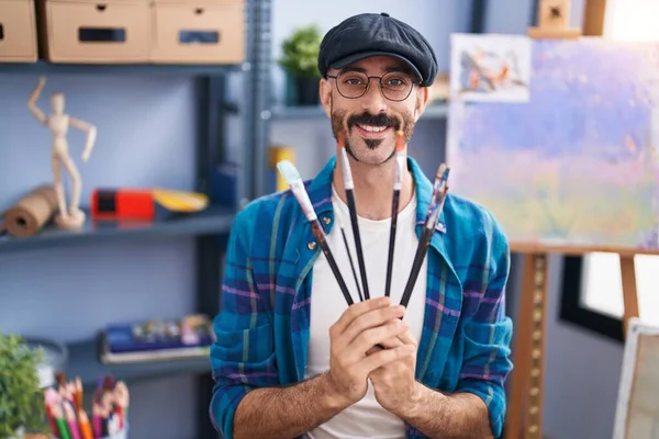 Young Hispanic Man Artist Smiling Confident Holding Paintbrushes Art Studio —  Fotos de Stock