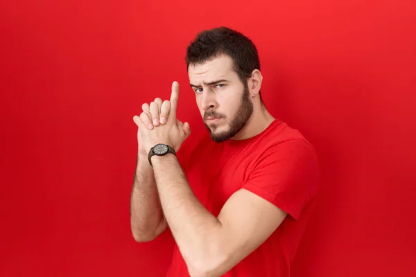 Young Hispanic Man Wearing Casual Red Shirt Holding Symbolic Gun — Foto de Stock
