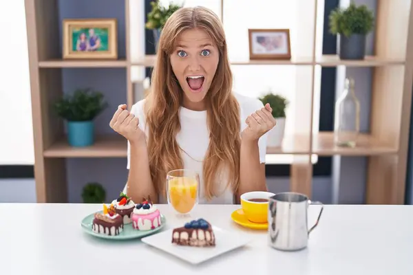 Jovem Caucasiana Comendo Bolos Para Café Manhã Comemorando Surpreso Surpreso — Fotografia de Stock