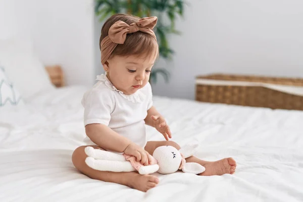 Liebenswertes Kaukasisches Baby Sitzt Auf Bett Und Spielt Mit Puppe — Stockfoto