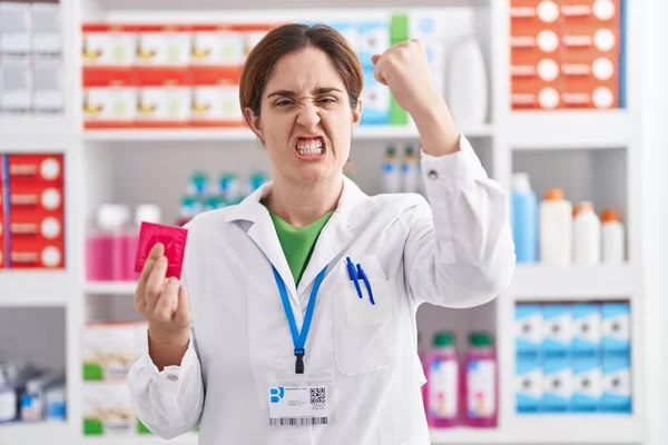 Brunette Woman Working Pharmacy Drugstore Holding Condom Annoyed Frustrated Shouting — Stock Photo, Image