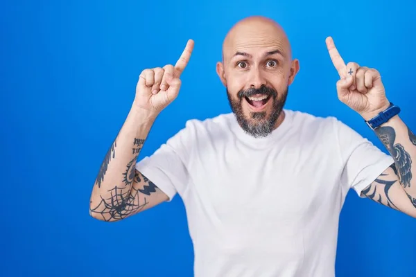 Ισπανόφωνος Άνδρας Τατουάζ Στέκεται Πάνω Από Μπλε Φόντο Χαμογελώντας Έκπληκτος — Φωτογραφία Αρχείου