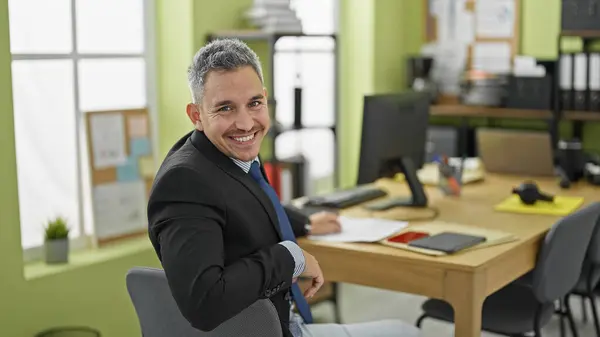 若いヒスパニックの男ビジネスワーカーは オフィスで笑顔の文書を読む — ストック写真