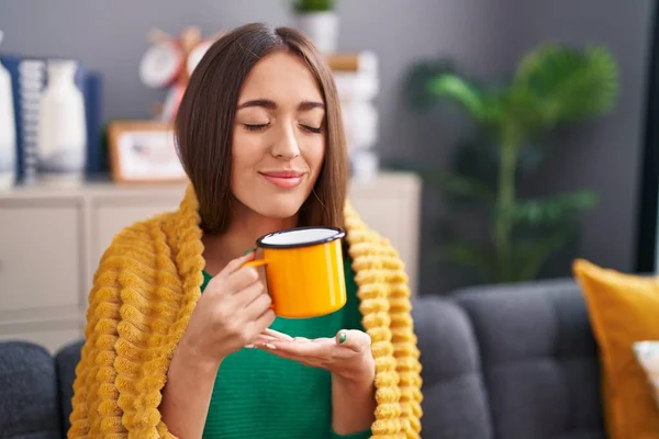 Young Beautiful Hispanic Woman Smelling Coffee Sitting Sofa Home — Stock Photo, Image