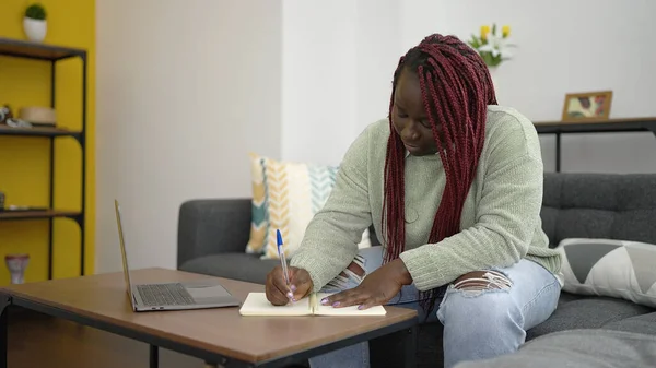 自宅でノートパソコンの書き込みを使用して編組髪を持つアフリカの女性 — ストック写真