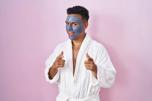 Junger Hispanischer Mann Mit Schönheitsgesichtsmaske Und Bademantel Der Mit Fröhlichem — Stockfoto