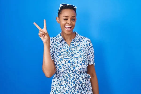 African American Woman Standing Blue Background Smiling Happy Face Winking — Stockfoto