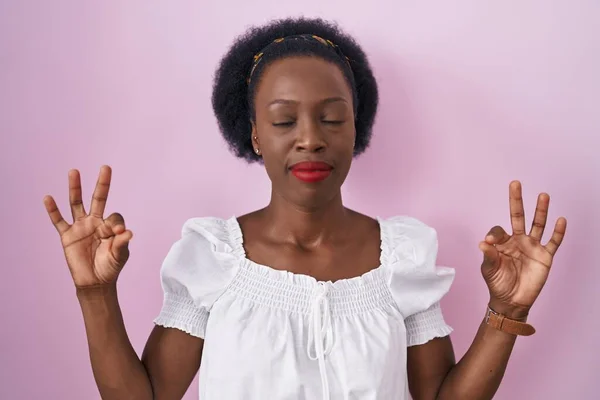 Африканская Женщина Вьющимися Волосами Стоящими Розовом Фоне Расслаблена Улыбается Закрытыми — стоковое фото