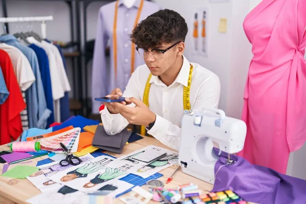 在裁缝店里 他的青少年小裁缝用智能手机给服装设计拍照 — 图库照片