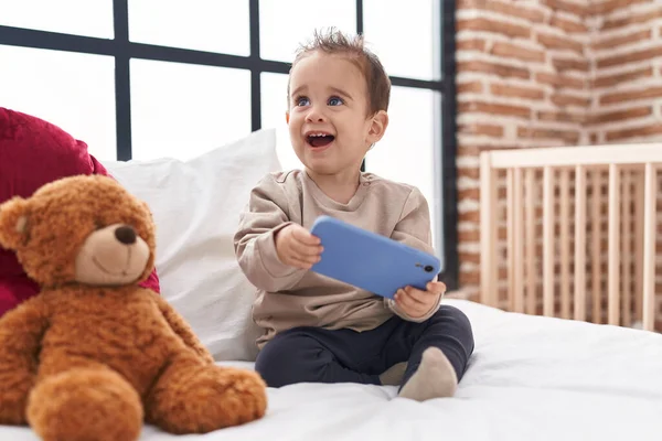Sevimli Spanyol Çocuk Elinde Akıllı Telefonuyla Yatak Odasında Oturuyor — Stok fotoğraf