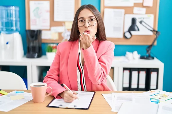 Young Hispanic Woman Working Office Wearing Glasses Looking Camera Blowing — Stockfoto