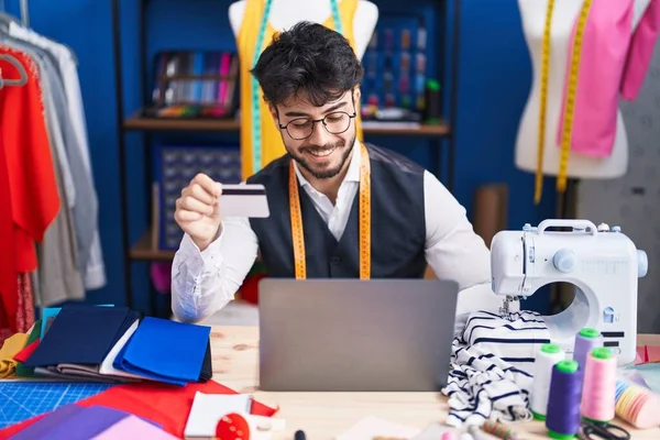 Young Hispanic Man Tailor Using Laptop Credit Card Sewing Studio — Stockfoto