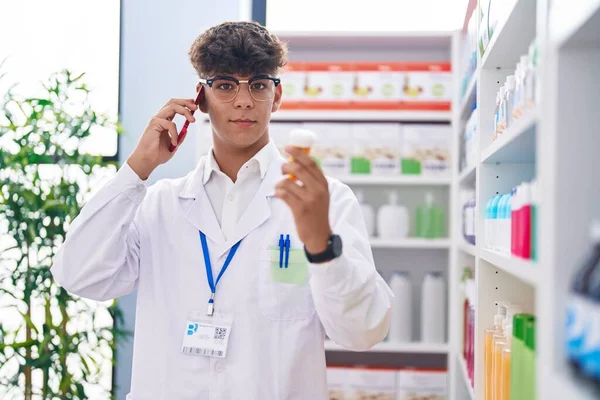 Jovem Hispânico Adolescente Farmacêutico Segurando Pílulas Garrafa Falando Smartphone Farmácia — Fotografia de Stock