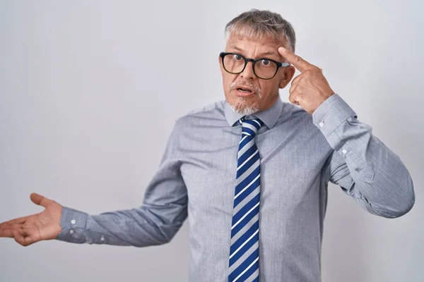 眼鏡をかけて灰色の髪を持つヒスパニック系のビジネスマンは混乱し コピースペースを示し 額に指を指すヤシに悩まされました 考えてみてください — ストック写真